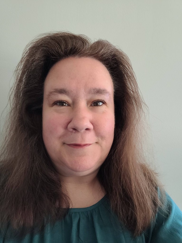 headshot of co-owner Tammy Harris, smiling in a teal blouse.